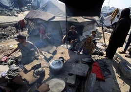 Palestinos desplazados preparan alimentos en un campamento en Gaza.