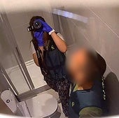 Punto de vista de la cámara oculta muestra agentes de la Guardia Civil investigando el baño.