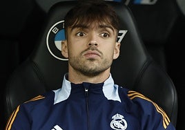 El jugador madridista Raúl Asencio, en el banquillo durante un partido.