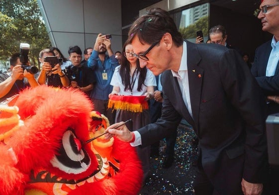 El presidente de la Generalitat, Salvador Illa, pinta sobre un dragón, durante su visita este viernes a Shangai.