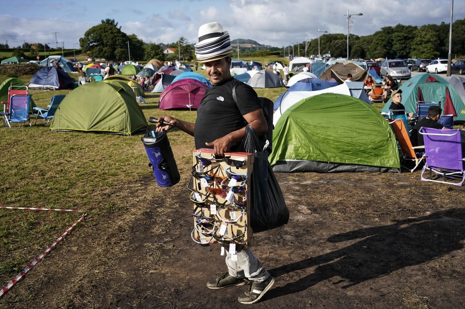 Un vendedor ambulante recorre el camping horas antes de la verbena.