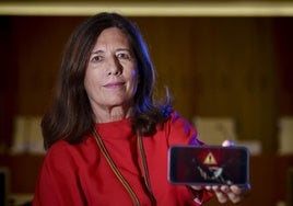 Mar España muestra la pantalla de su móvil.