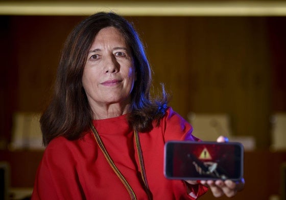 Mar España muestra la pantalla de su móvil.