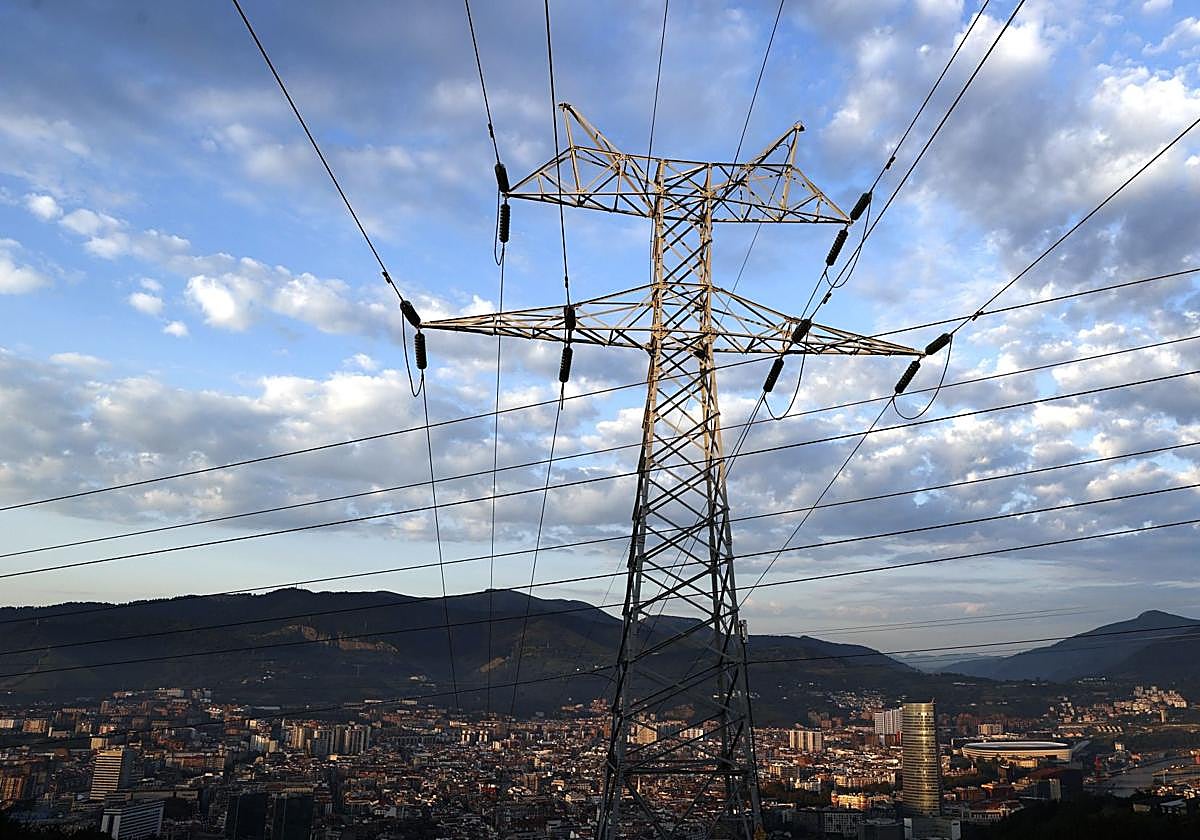 Una torre de transporte de energía con la ciudad de Bilbao de fondo