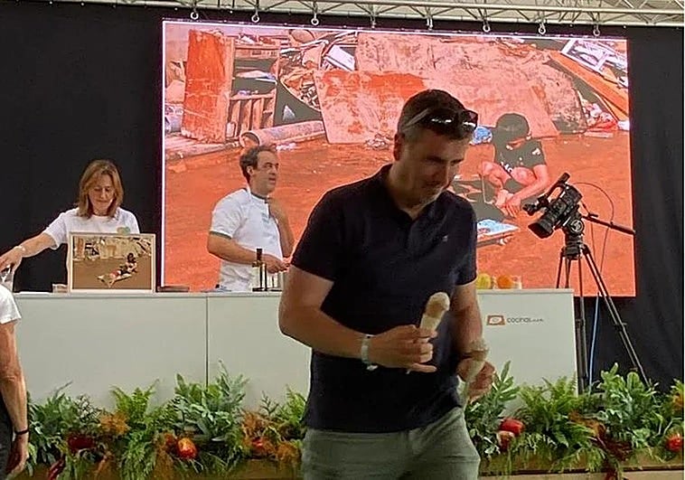 Angelines González y Fernando Sáenz, durante la presentación del helado que se dispone a degustar uno de los asistentes al festival gastronómico Mama; al fondo, imágenes del paisaje arrasado por la dana que inspiran su creacion.