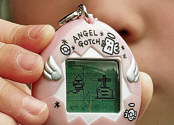 Una niña muestra su tamagotchi en 1997.