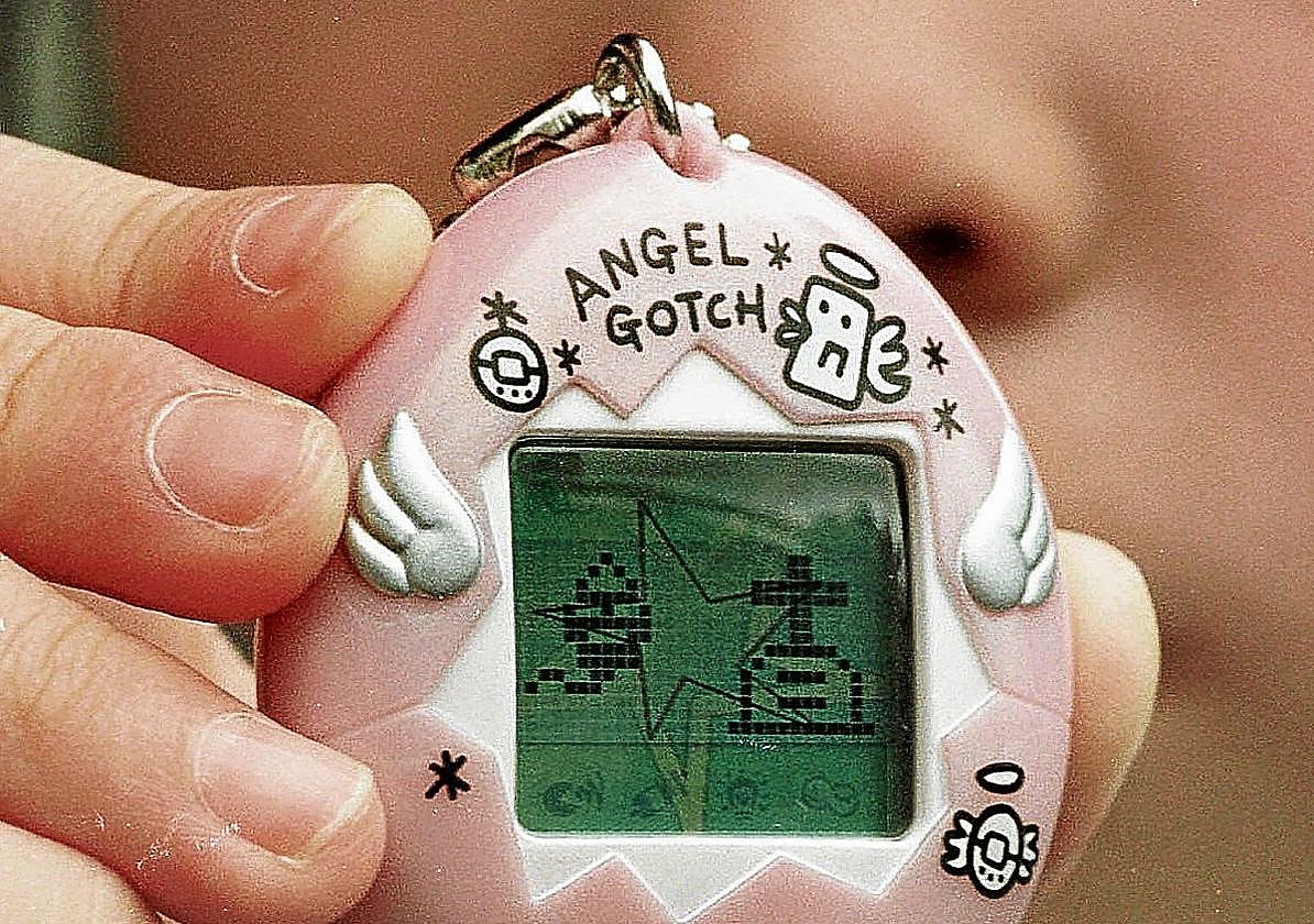 Una niña muestra su tamagotchi en 1997.