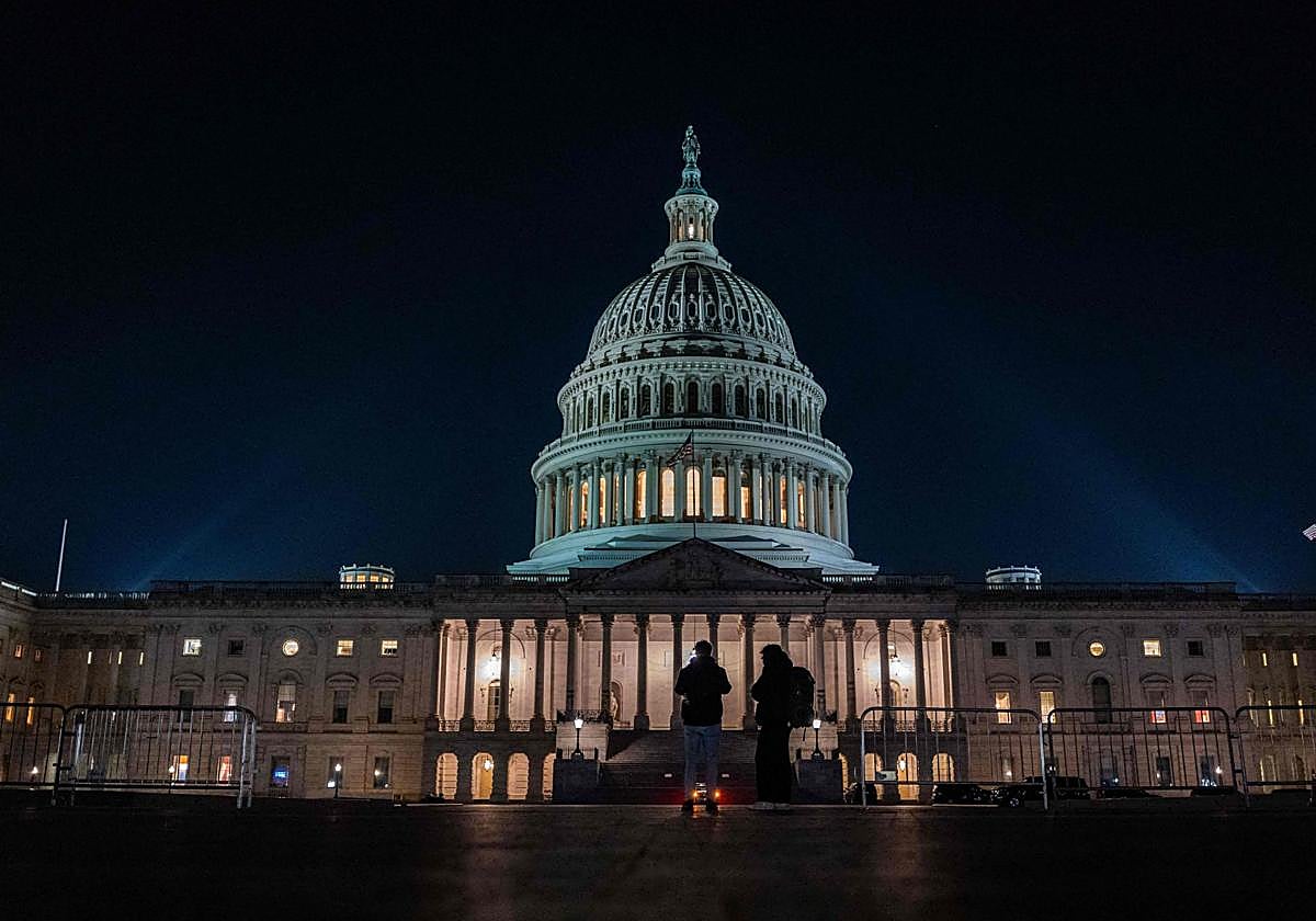 Dos turistas toman fotografías frente al edificio del Capitolio.