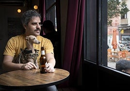Ernesto Sevilla en un bar de Madrid junto a su galgo italiano, Elvis, que le acompaña desde 2019.