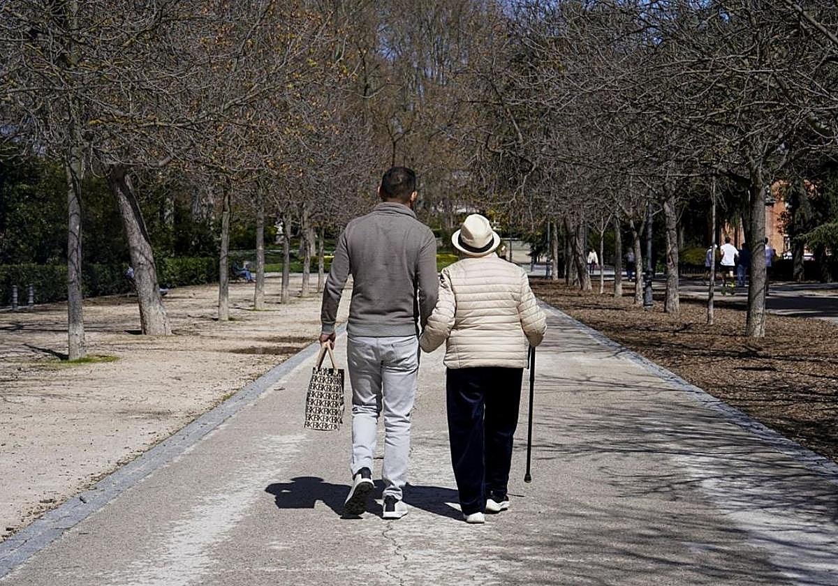 Un jubilado pasea por un parque.