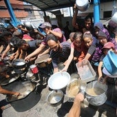 Palestinos aguardan para recoger algo de comida en Ciudad de Gaza.