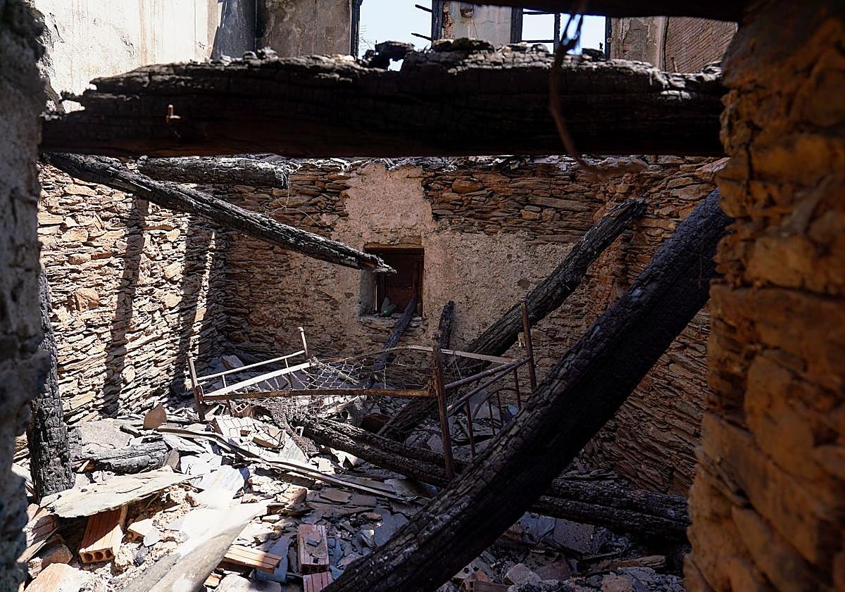 Imagen principal - Arriba, el interior de la casa quemada en San Xulian. Abajo, Mangueras y palas usadas para apagar el fuego y alrededores del San Xulian con todo el monte quemado.