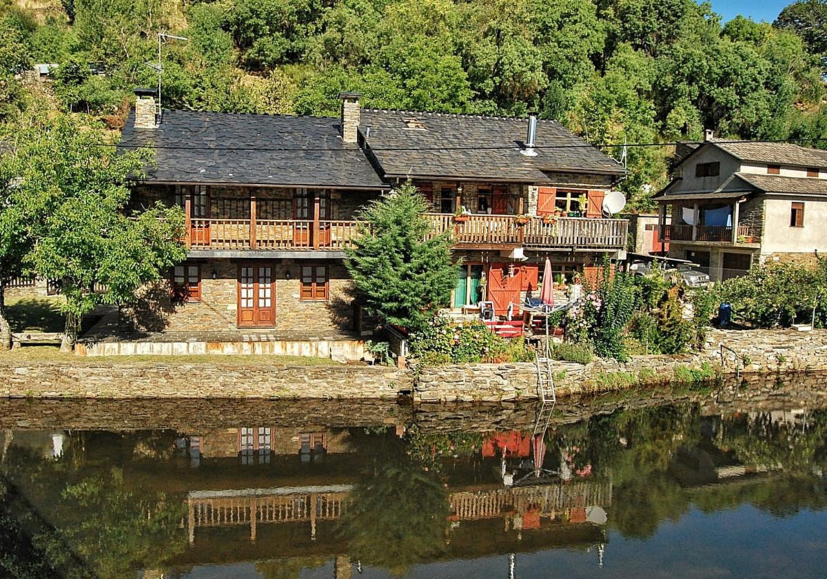 Rio de Onor. Las casas del pueblo doble se reflejan en el río.