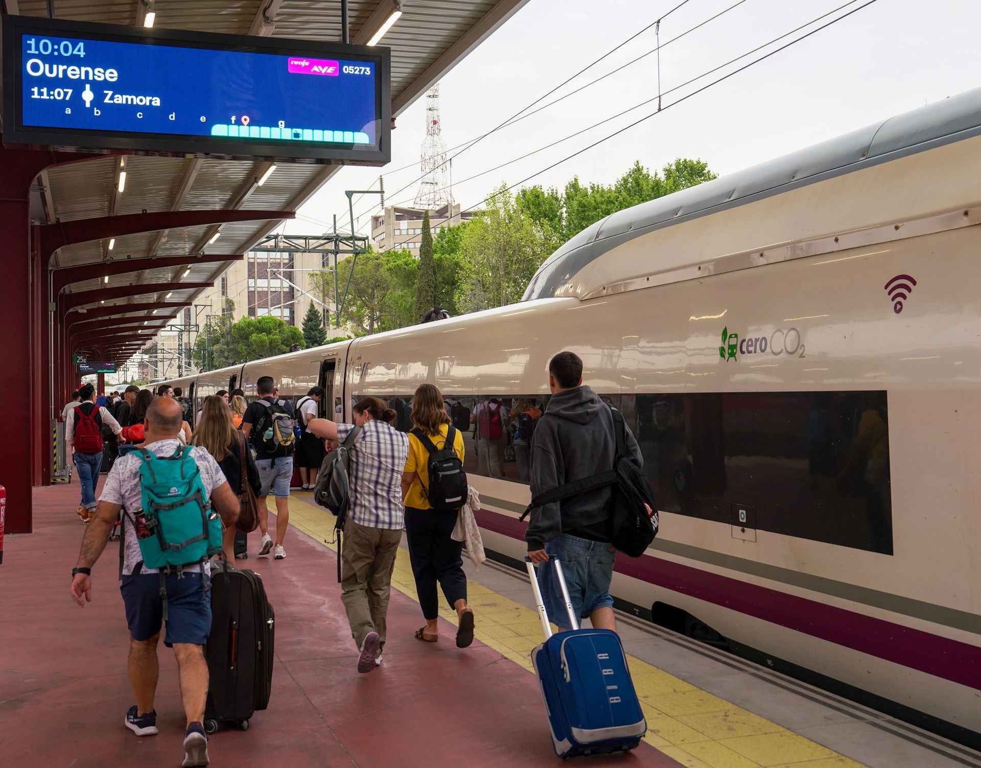 Pasajeros en el andén a punto de tomar el tren AVE en dirección Orense una vez restablecida la línea de alta velocidad con Galicia.