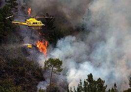 Un helicóptero combate las llamas del incendio asturiano de San Antolín de Ibias.