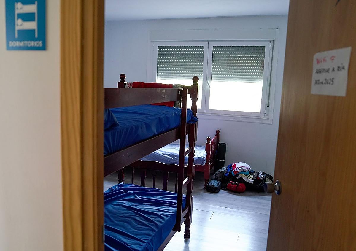 Imagen secundaria 1 - Arriba entrada al albergue de A Rúa. Abajo, uno de los dormitorios casi vacíos donde pernoctan los peregrinos. A la derecha, Montse Pérez descansa junto a su mochila después de terminar la etapa del día.