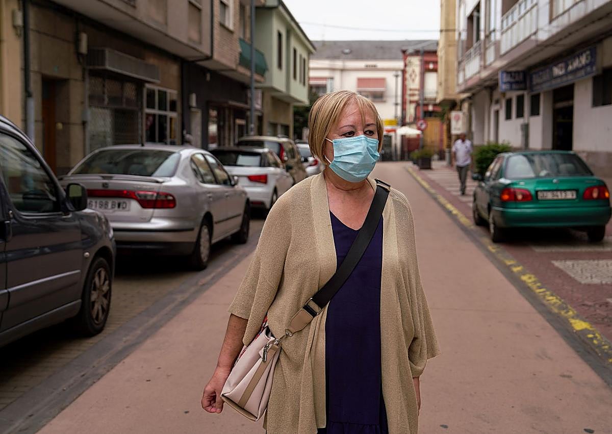 Imagen secundaria 1 - Arriba, cartel a la entrada abierta al vertedero. A la izquierda, María José Luengo, vecina del pueblo, con la mascarilla que usa cada vez que sale a la calle. A la derecha Javier Quintas, técnico farmacéutico despachando mascarillas.