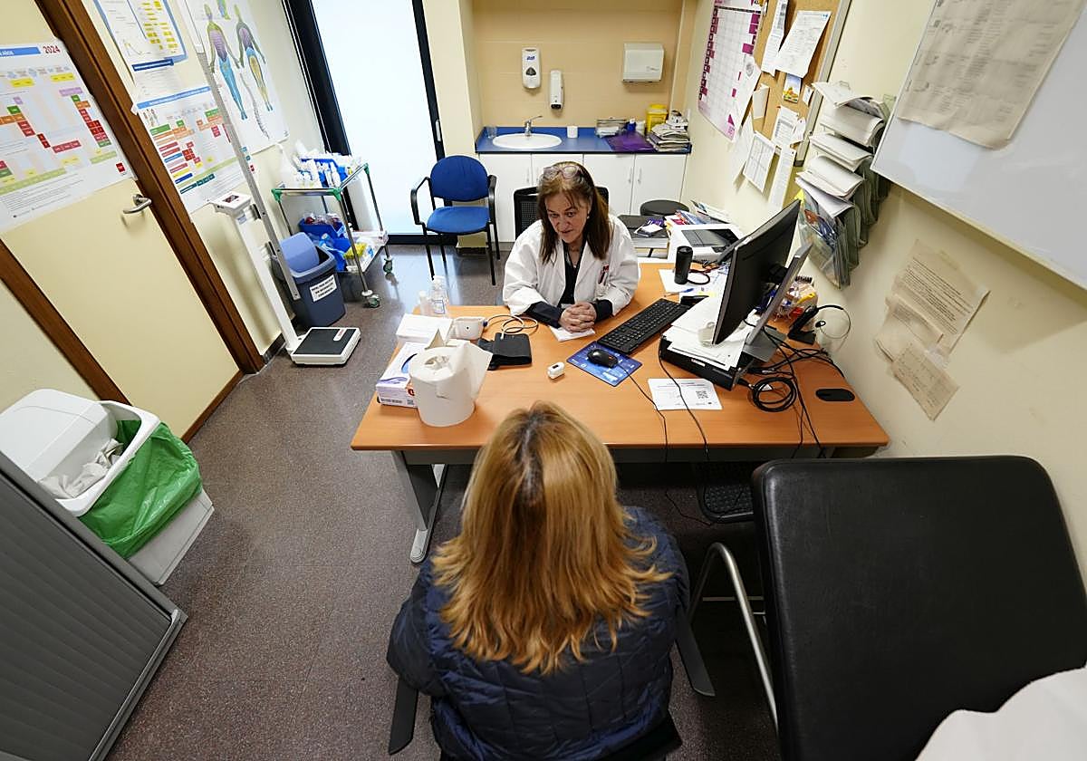 Un médico atendiendo en consulta a un paciente en un centro de salud público.