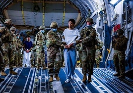 Militares estadounidenses escoltan a presuntos miembros del Tren de Aragua y el MS-13 para su deportación.