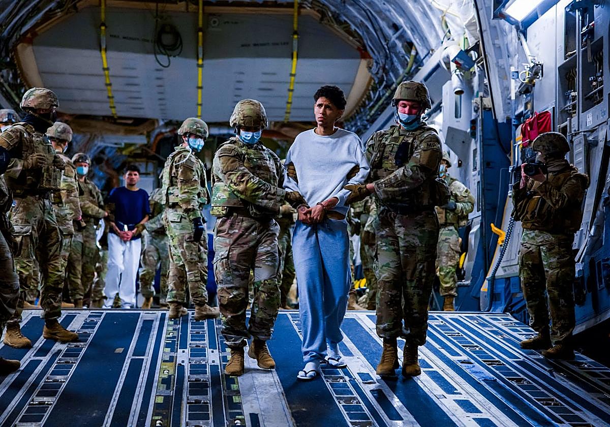 Militares estadounidenses escoltan a presuntos miembros del Tren de Aragua y el MS-13 para su deportación.