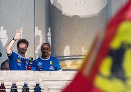 Los pilotos de Ferrari, Charles Leclerc y Lewis Hamilton, saludan a aficionados un evento.
