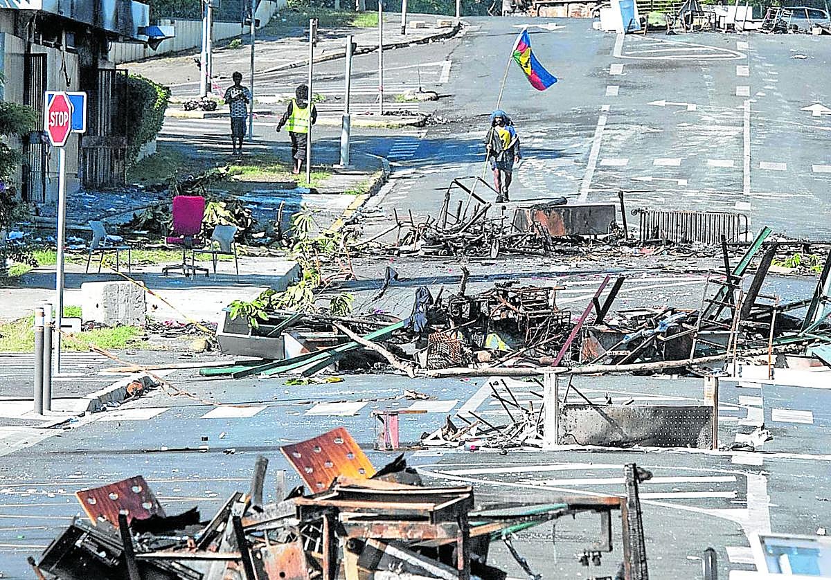 Una calle bloqueada por escombros y objets quemados tras los disturbios en Numea, territorio francés de Nueva Caledonia, en mayo de 2024