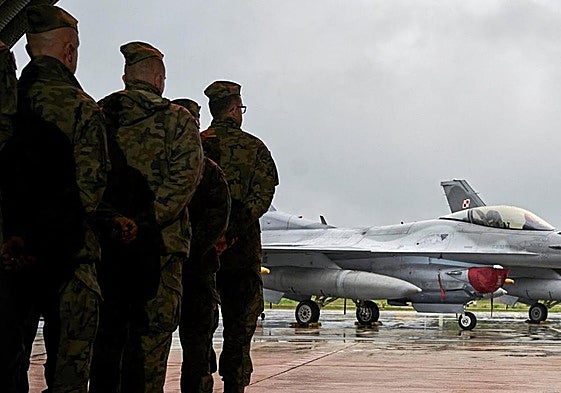 Los pilotos polacos que participaron en la interceptación de los drones rusos escuchan la felicitación del primer ministro Donald Tusk, frente a cazas F-16.