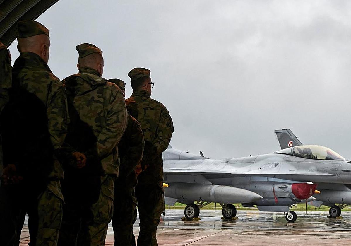 Los pilotos polacos que participaron en la interceptación de los drones rusos escuchan la felicitación del primer ministro Donald Tusk, frente a cazas F-16.