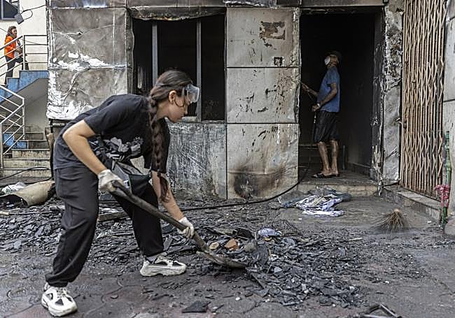 Una joven limpia una comisaría en la capital nepalí tras los disturbios.