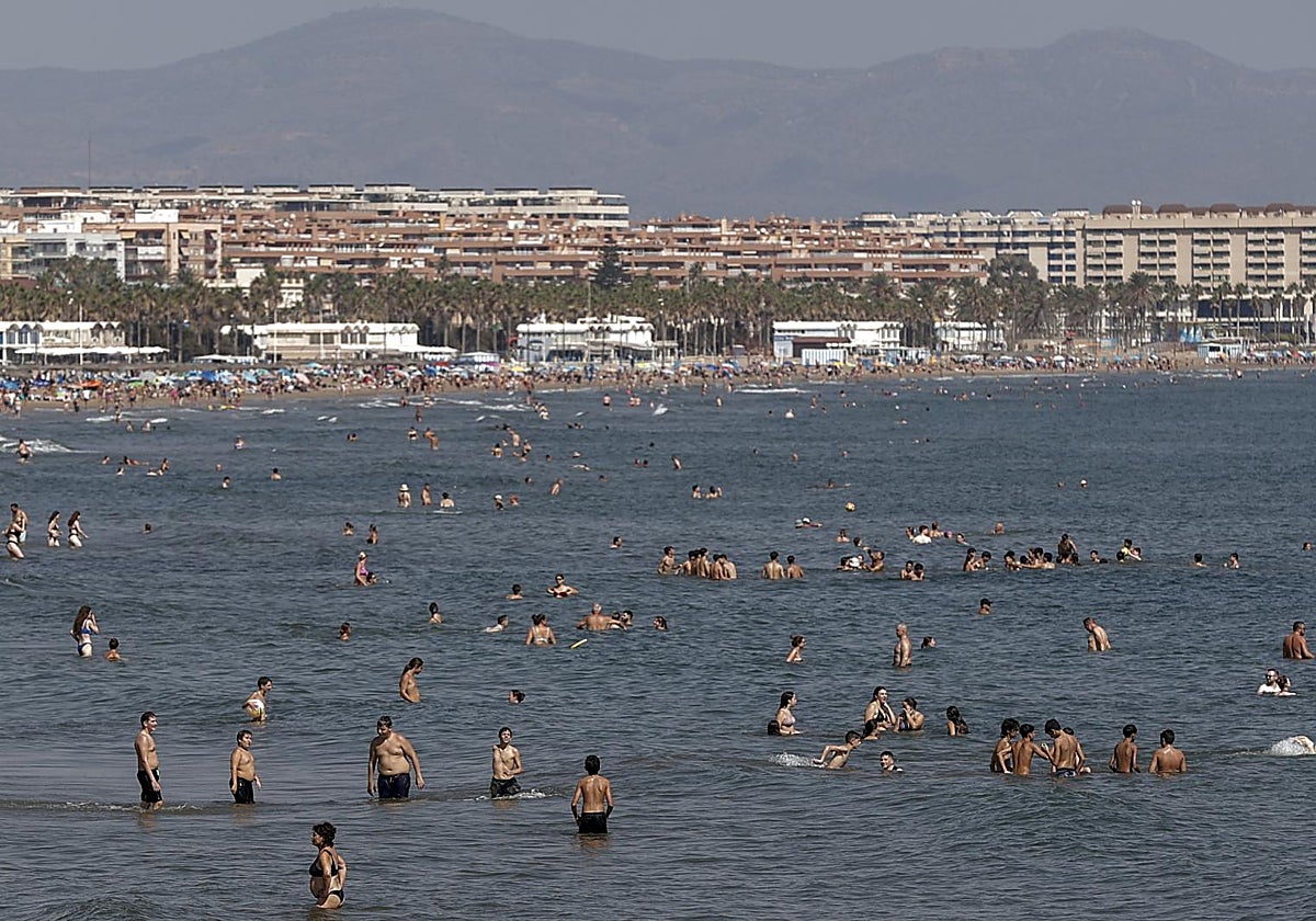 Bañistas se refrescan en aguas de la playa de la Malvarrosa, en Valencia.