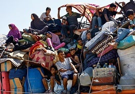 Una familia palestina huye de Gaza City en una camioneta cargada con todos sus enseres.