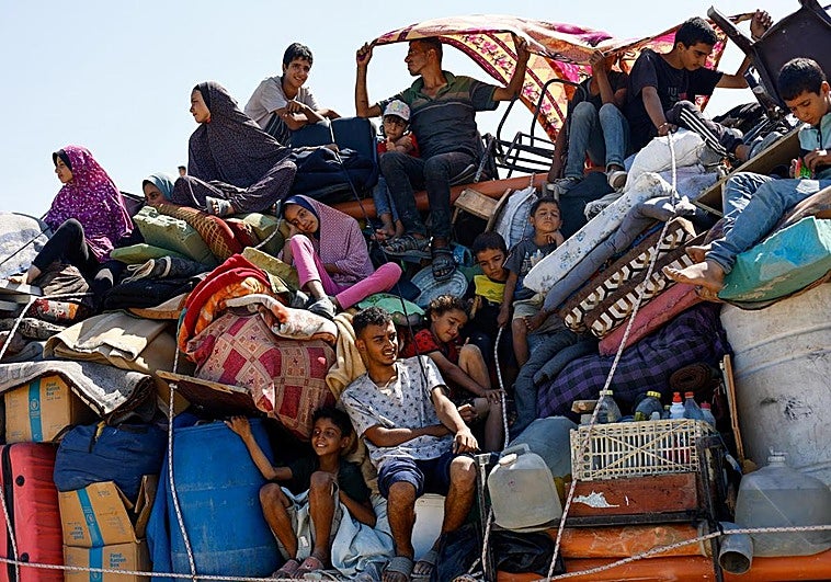 Una familia palestina huye de Gaza City en una camioneta cargada con todos sus enseres.