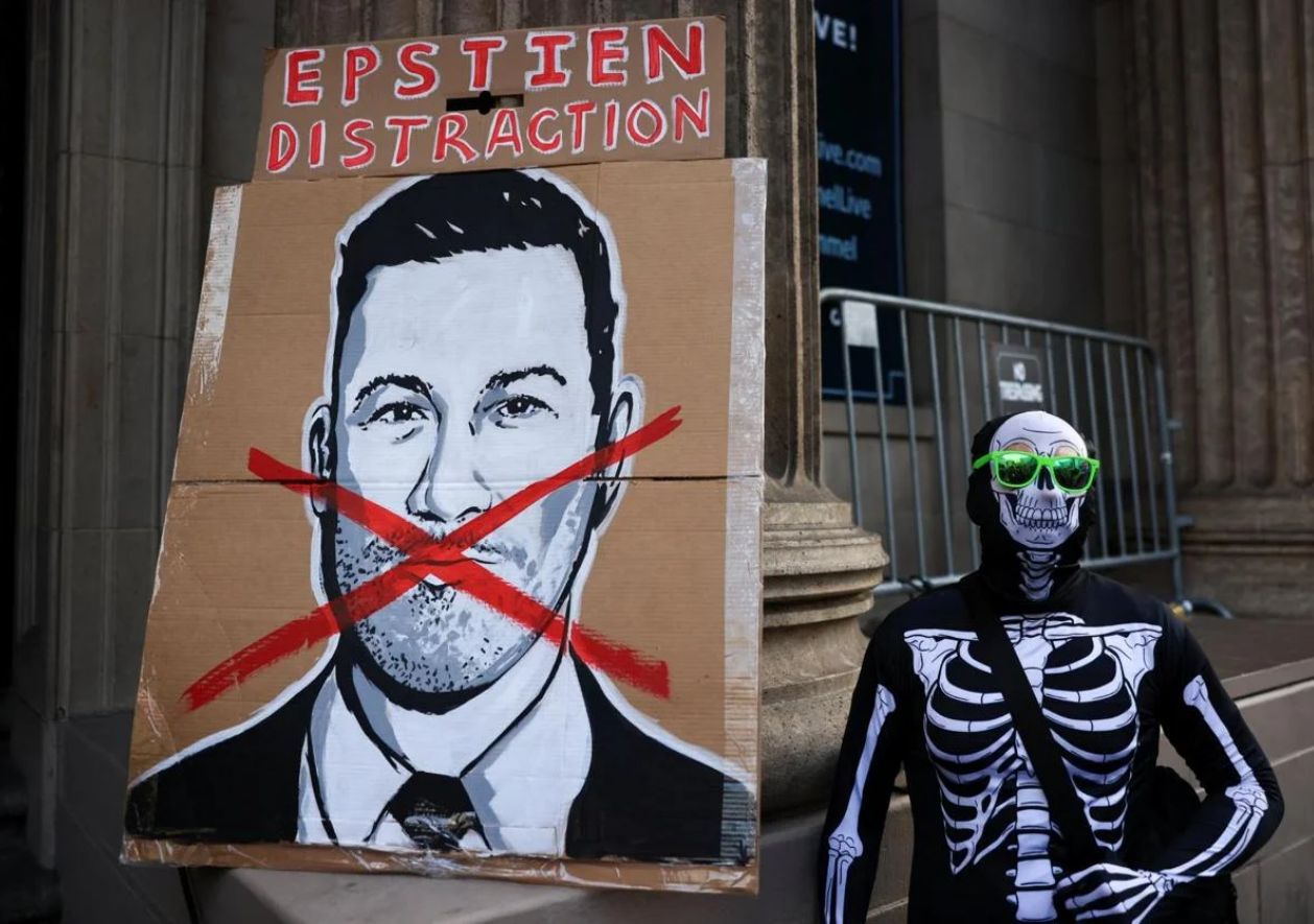 Un manifestante vestido con un traje de esqueleto junto a un cartel de Jimmy Kimmel durante una protesta por el despido del presentador.