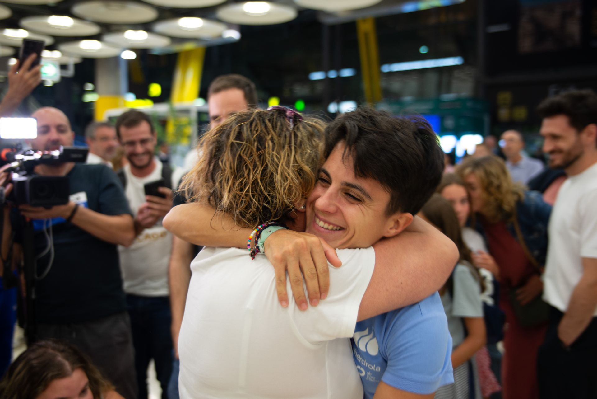 María Pérez se abraza a su uno de los familiares que han ido a recibirla al aeropuerto de Madrid.