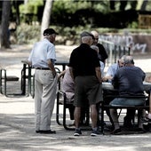 Un grupo de pensionistas juega al dominó en un parque.