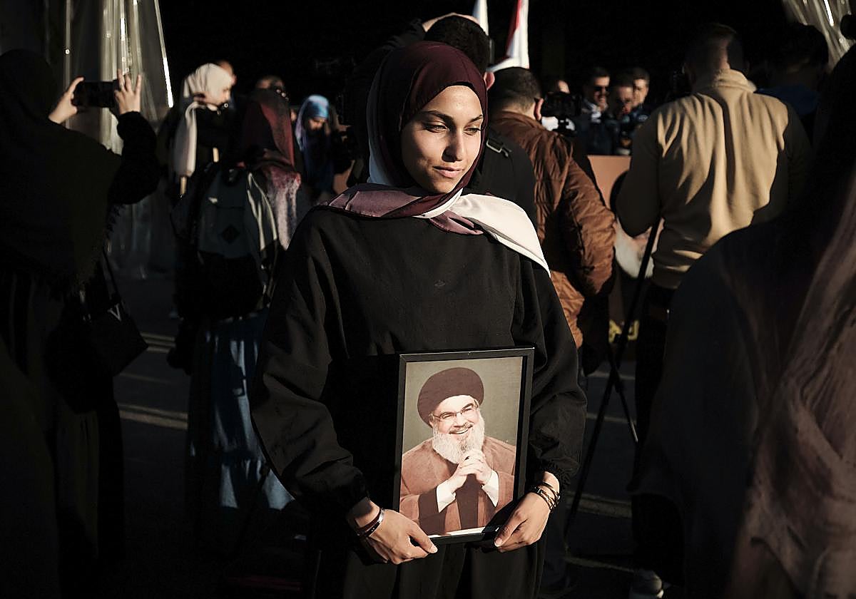 Una joven sostiene el retrato de Hasán Nasrala en Beirut.
