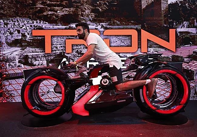 Hombre posa en la motocicleta de Tron.