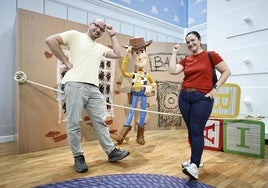 Una pareja posa con el personaje de Toy Story, Woody.