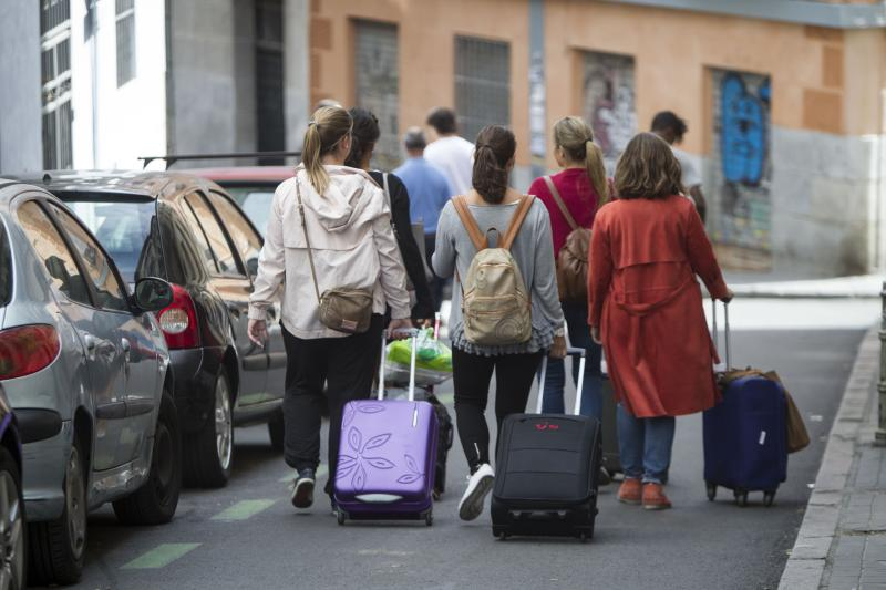 Turistas caminan con maletas por la calle