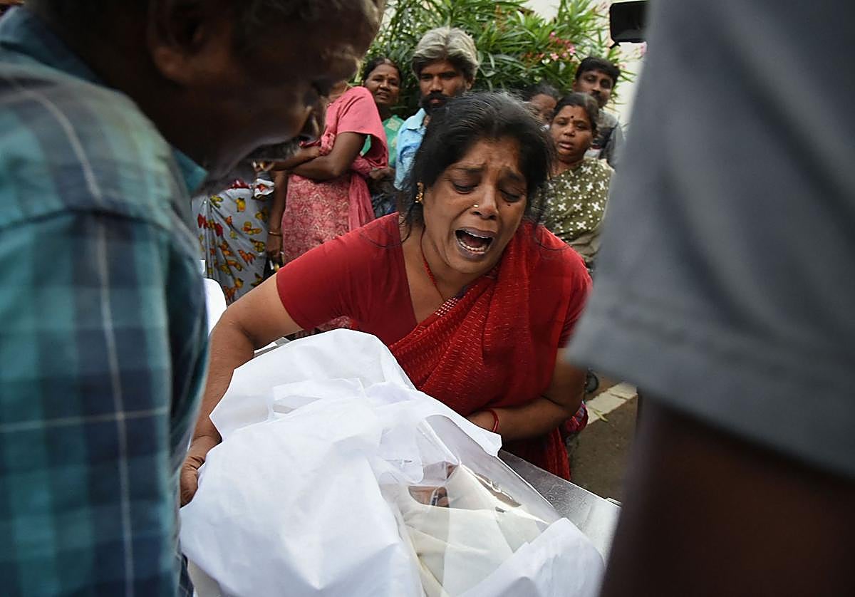 Una mujer sostiene el cuerpo de un familiar fallecido en la avalancha.