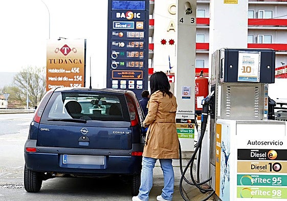 Una mujer echa gasolina al coche.