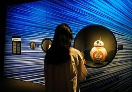 Una joven observa la marioneta del androide BB-8 utilizada en 'Star Wars: El despertar de la fuerza'.