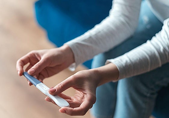 Una mujer contempla el resultado de un test de embarazo.