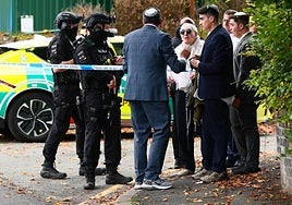 Agentes de policía armados conversan con miembros de la comunidad cerca de la sinagoga de la Heaton Park Hebrew Congregation tras el atentado.