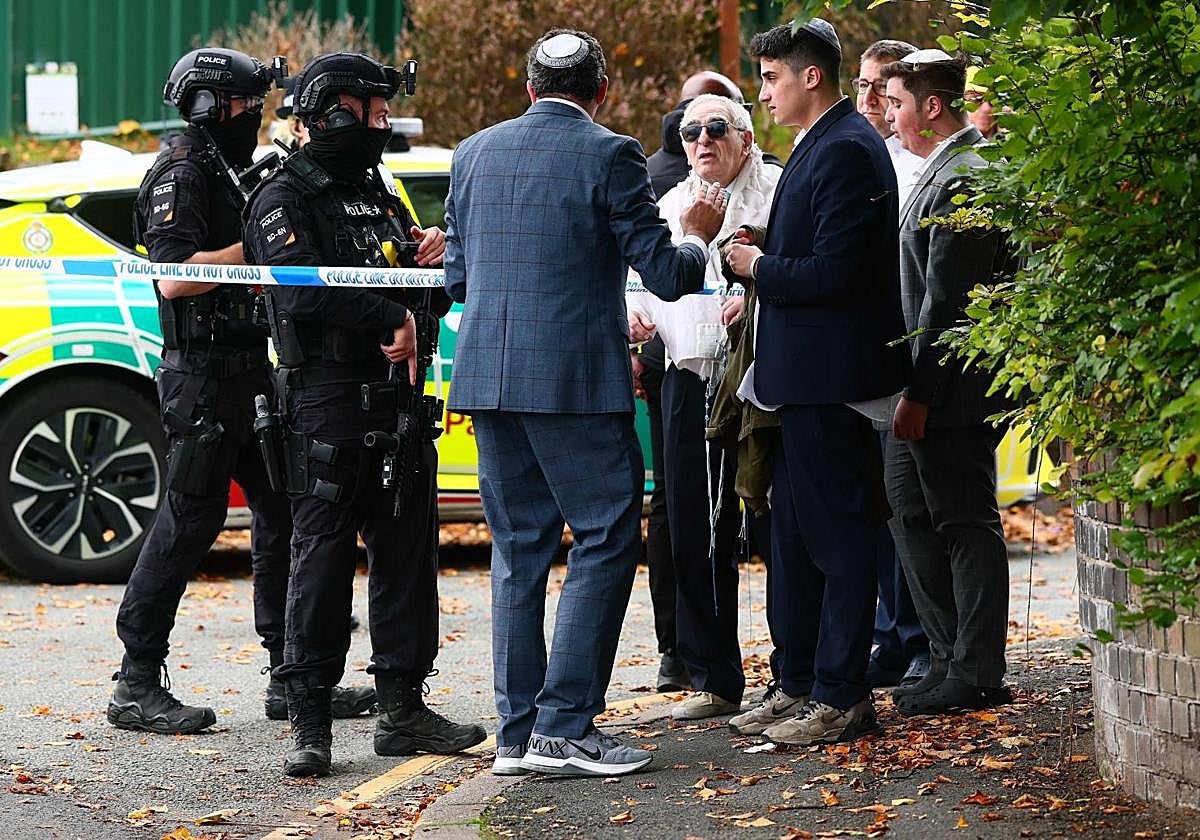 Agentes de policía armados conversan con miembros de la comunidad cerca de la sinagoga de la Heaton Park Hebrew Congregation tras el atentado.