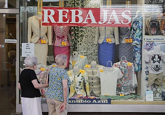 Dos mujeres miran el escaparate de una tienda de ropa.
