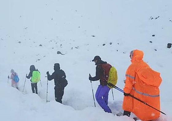 Imagen de un grupo de excursionistas abandonando su campamento en medio de la nieve.