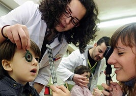 Dos ópticas realizan las pruebas de visión a un alumno del colegio Nuestra Señora de Atocha de Murcia.