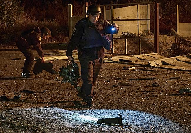 Un miembro de los equipos de rescate de Ucrania recoge el motor de un dron ruso tras un ataque sobre Járkov.