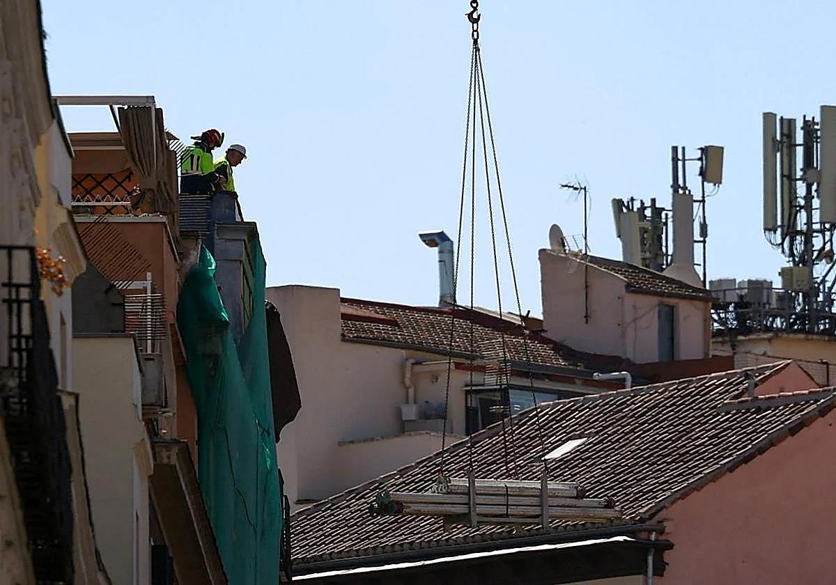 Bomberos inspeccionan la fachada del edificio siniestrado.